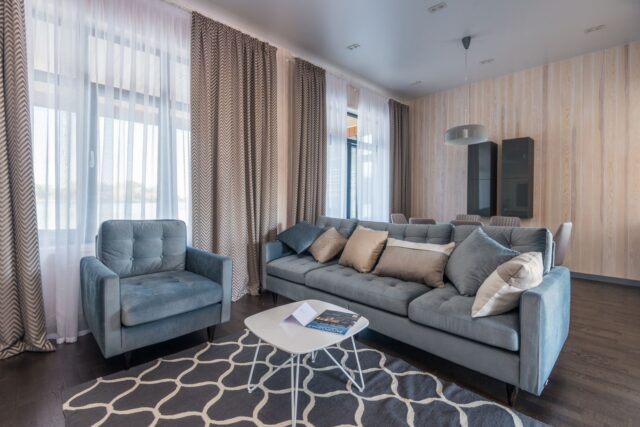 Sufragerie de apartament cu draperii groase, covor moale și bibliotecă, amenajată pentru mai multă liniște